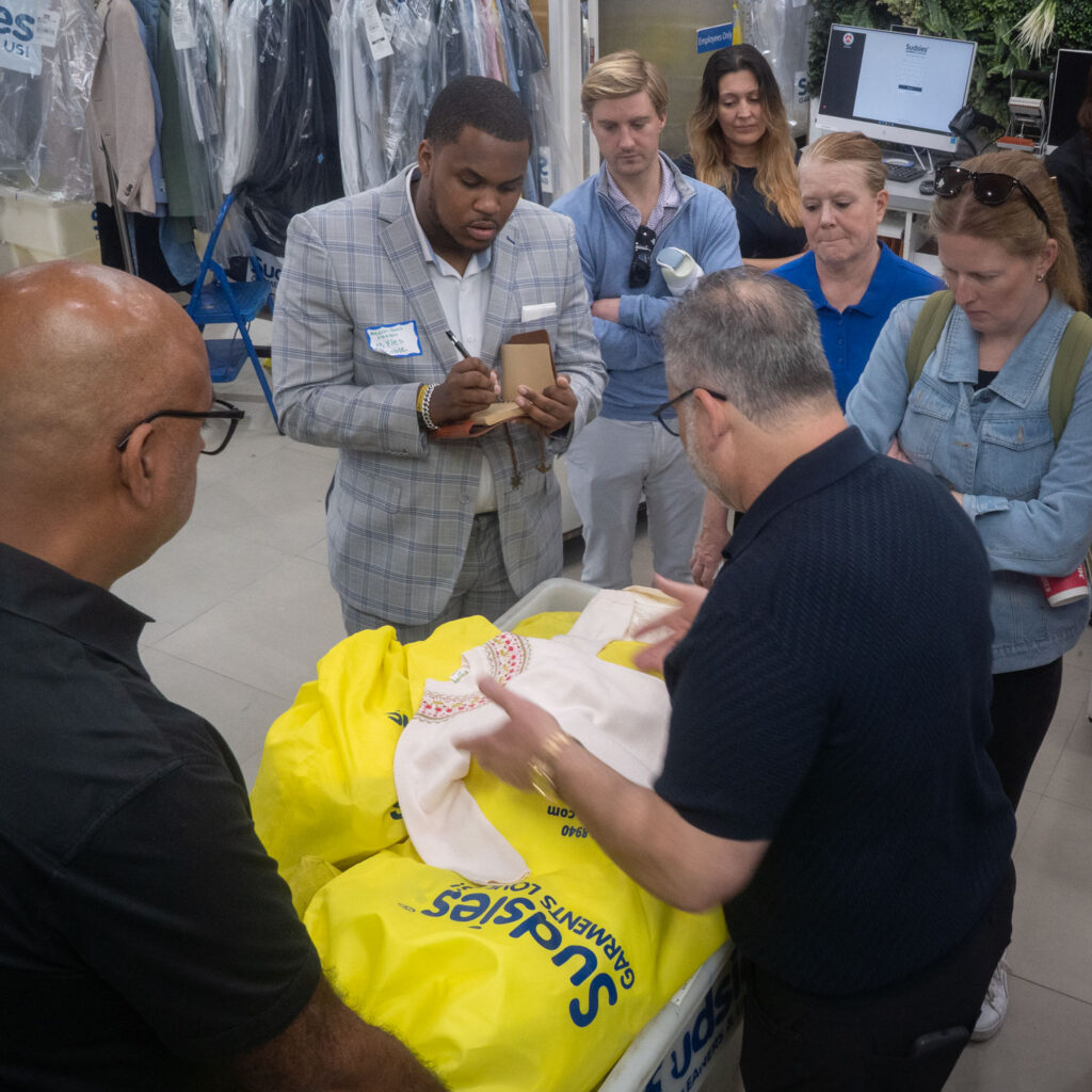 Team reviewing garment details during hands-on fabric training session