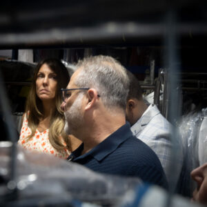 Team members reviewing garments inside a dry cleaning facility