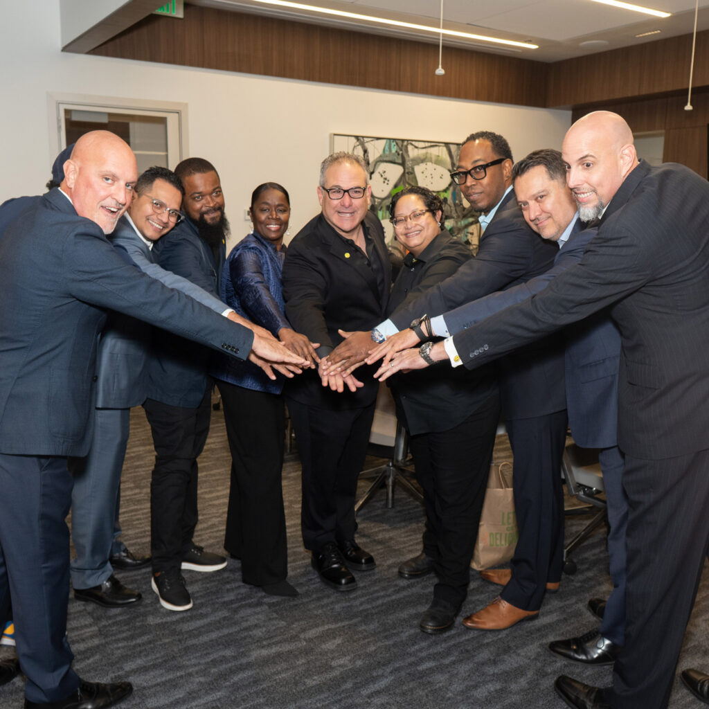 Diverse leadership team standing together with hands joined during a collaborative business meeting