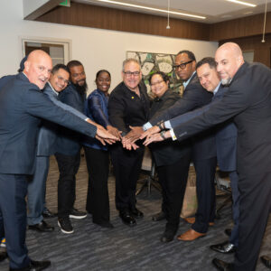 Diverse leadership team standing together with hands joined during a collaborative business meeting